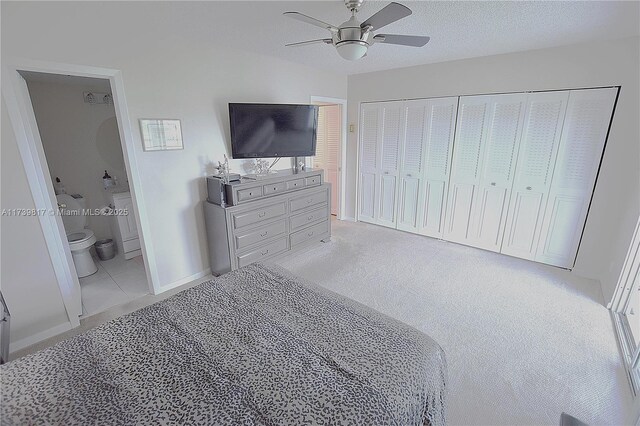 carpeted bedroom with ensuite bathroom, ceiling fan, a textured ceiling, and a closet