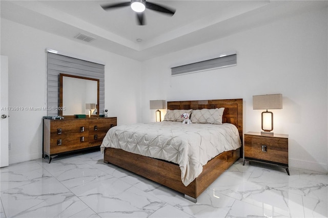 bedroom with ceiling fan and a raised ceiling