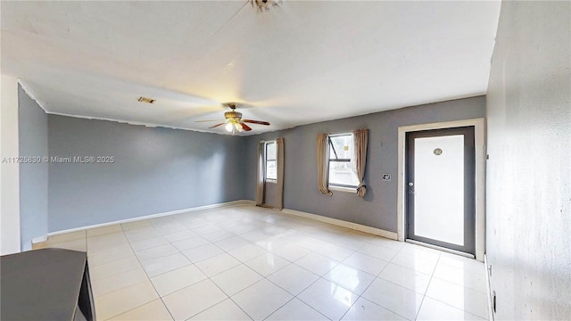 spare room featuring ceiling fan, light tile patterned flooring, and baseboards