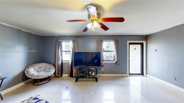 unfurnished living room featuring tile patterned floors, a ceiling fan, and baseboards