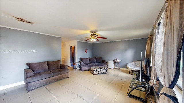 living area with a ceiling fan, baseboards, and light tile patterned floors