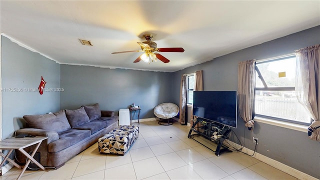 living area featuring visible vents, plenty of natural light, baseboards, and ceiling fan