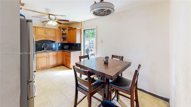 dining area with light floors, ceiling fan, and baseboards