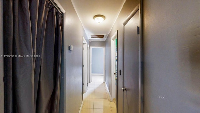 corridor featuring attic access, visible vents, and light tile patterned flooring