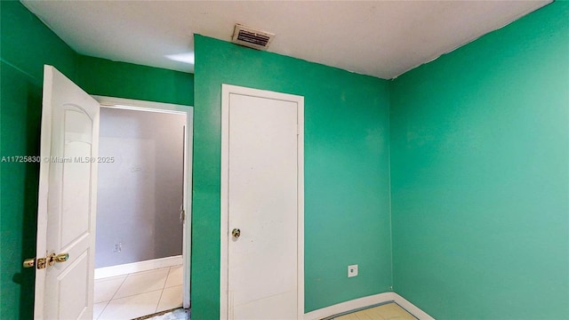 unfurnished bedroom with light tile patterned flooring, visible vents, and baseboards