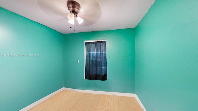 unfurnished room featuring ceiling fan and baseboards