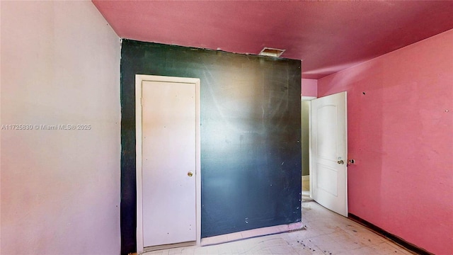 spare room with baseboards and visible vents