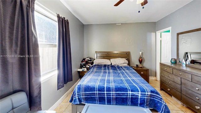 bedroom featuring light tile patterned floors, baseboards, and a ceiling fan