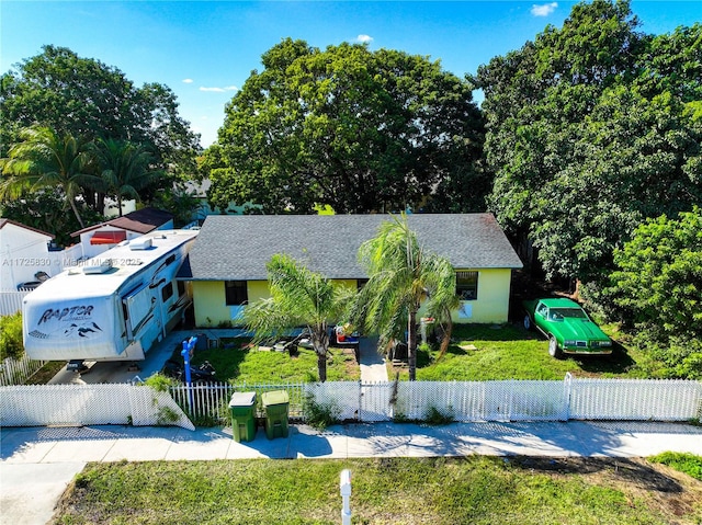 view of front of house featuring a fenced front yard and roof with shingles