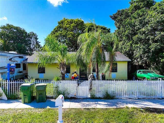 view of front of home with a fenced front yard and stucco siding