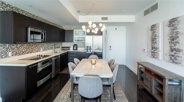 kitchen featuring pendant lighting, decorative backsplash, stainless steel appliances, and dark hardwood / wood-style floors