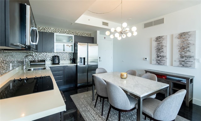 dining room with dark wood-type flooring, a chandelier, and sink