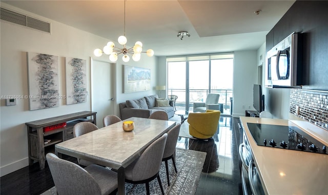 dining area featuring dark hardwood / wood-style flooring and a notable chandelier