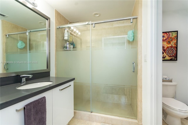 bathroom featuring vanity, toilet, and an enclosed shower