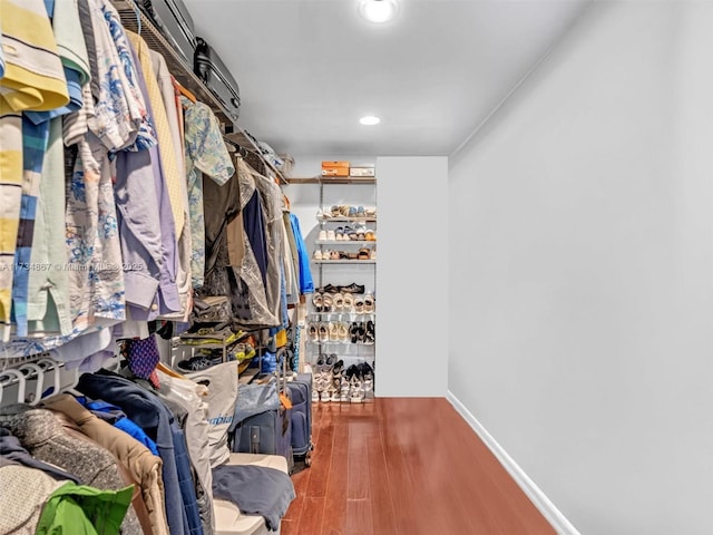 walk in closet with wood finished floors