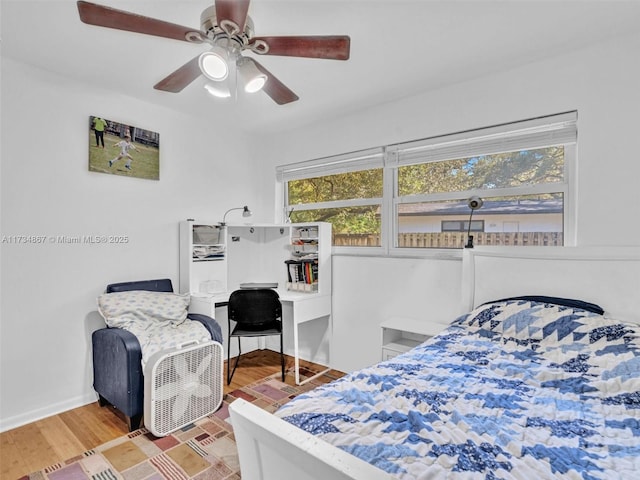 bedroom with baseboards, a ceiling fan, and wood finished floors