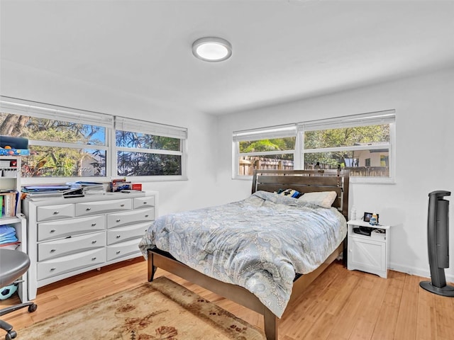 bedroom featuring baseboards and light wood finished floors