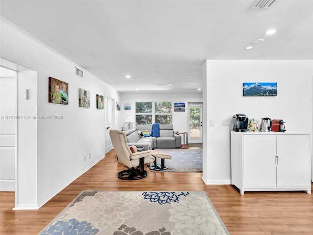 living room with light wood finished floors, visible vents, and recessed lighting