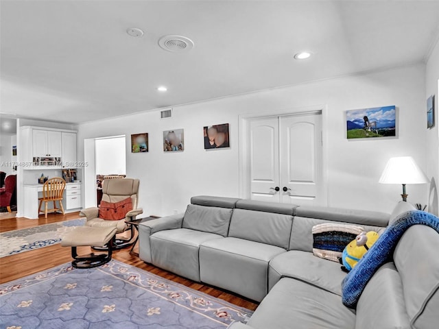 living area featuring recessed lighting, visible vents, and wood finished floors