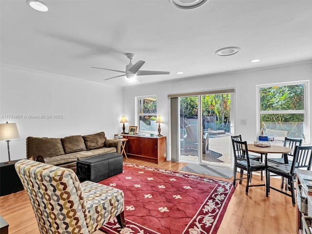 living room featuring a ceiling fan, light wood-type flooring, crown molding, and recessed lighting