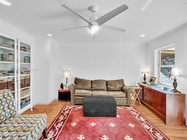 living area with ceiling fan, ornamental molding, and light wood-style flooring