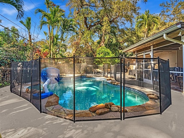 view of swimming pool featuring a patio area, fence, and a fenced in pool