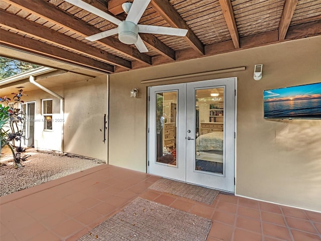 view of exterior entry with stucco siding, ceiling fan, a patio, and french doors