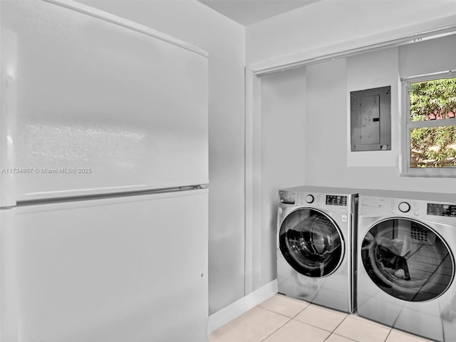 clothes washing area with laundry area, electric panel, washer and clothes dryer, and tile patterned floors