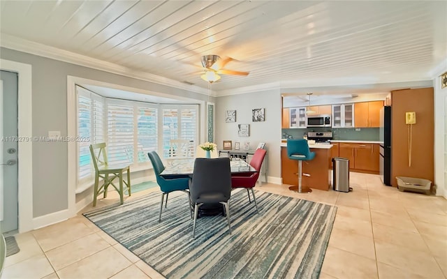 tiled dining space with crown molding and ceiling fan