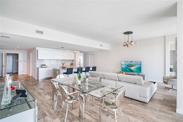 dining space with a chandelier and light wood-type flooring