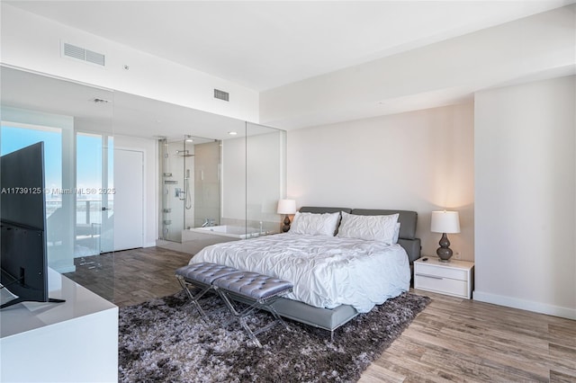 bedroom with visible vents, baseboards, and wood finished floors