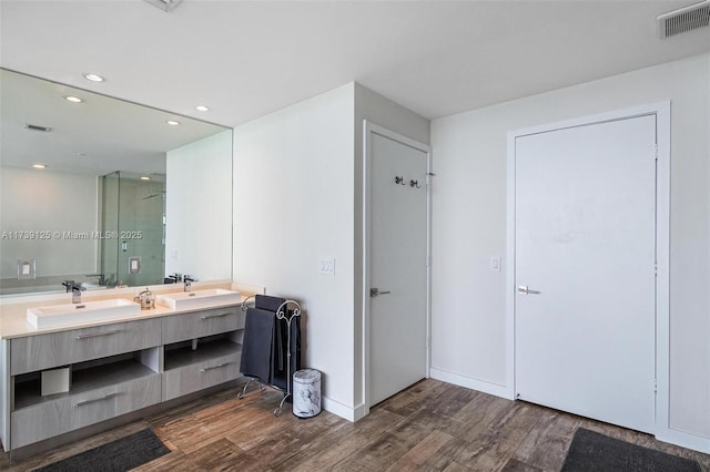 bathroom featuring vanity, wood-type flooring, and walk in shower