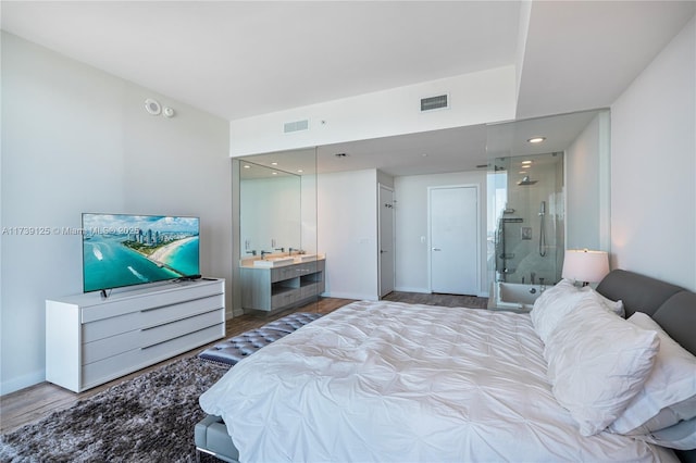 bedroom featuring baseboards, visible vents, and wood finished floors