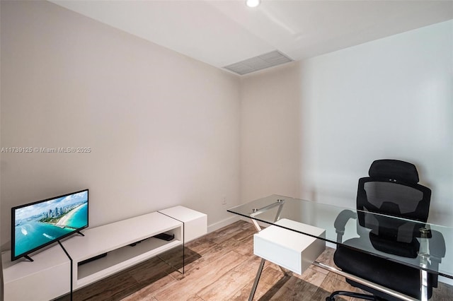 office space featuring light wood-type flooring, baseboards, and visible vents