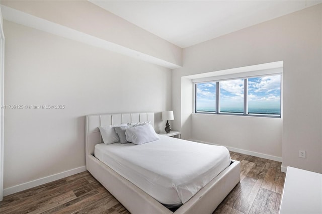 bedroom featuring dark wood finished floors and baseboards