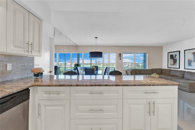 kitchen with stone countertops, white cabinets, hanging light fixtures, stainless steel dishwasher, and kitchen peninsula