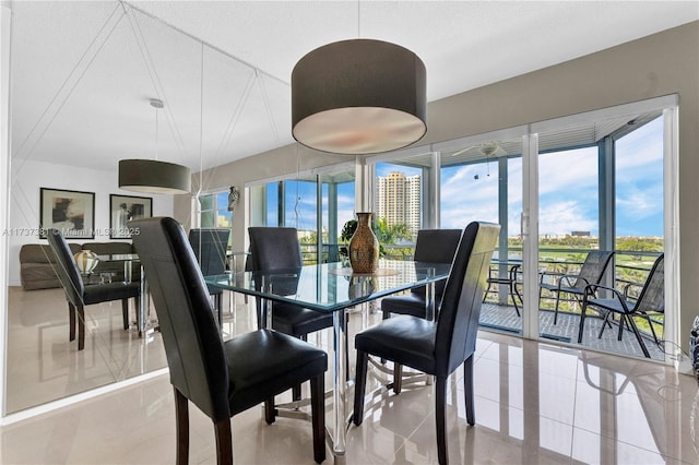 dining space featuring light tile patterned floors, a textured ceiling, and a healthy amount of sunlight