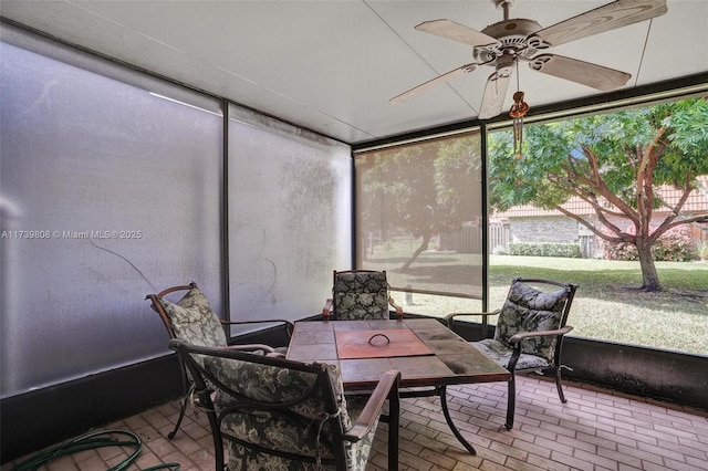 sunroom / solarium featuring ceiling fan and outdoor dining area