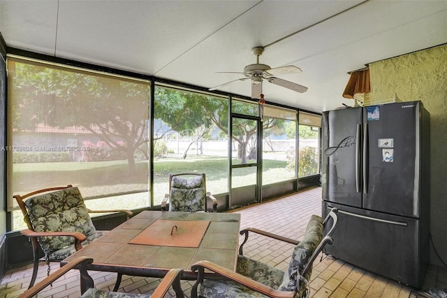 sunroom featuring ceiling fan and outdoor dining area