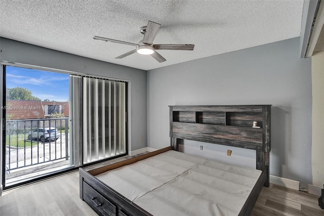 bedroom featuring wood finished floors, access to outside, a textured ceiling, and ceiling fan
