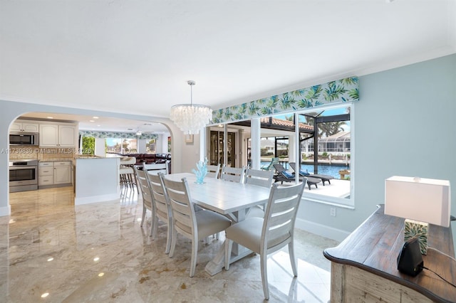 dining space with a chandelier, arched walkways, marble finish floor, and baseboards