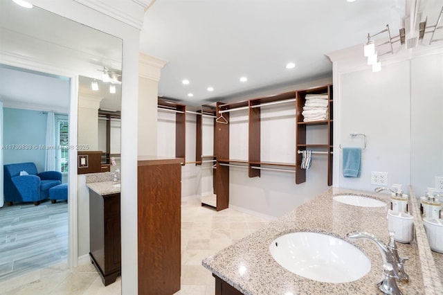 full bathroom with double vanity, ornamental molding, a sink, and recessed lighting