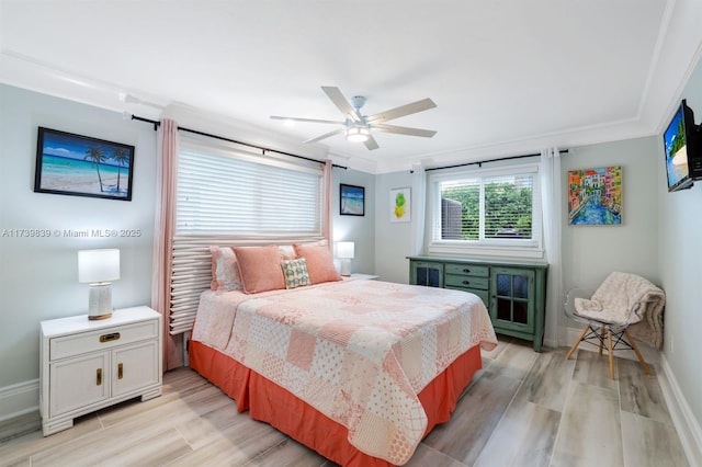 bedroom featuring crown molding, light wood-style flooring, baseboards, and ceiling fan