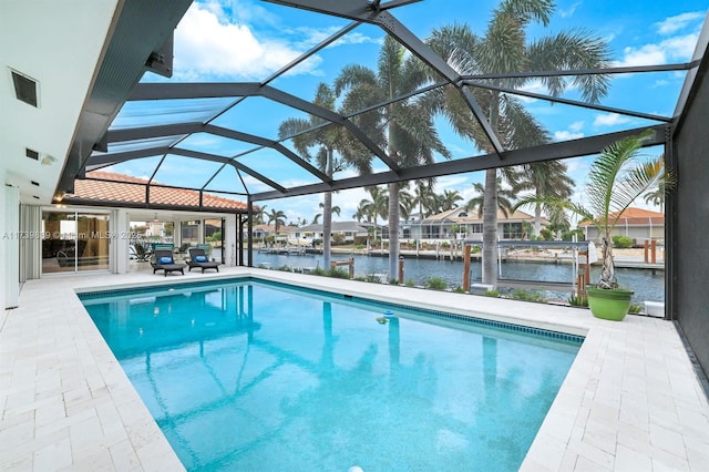 outdoor pool featuring a water view, glass enclosure, and a patio area