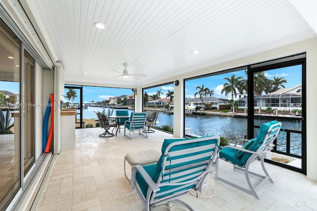 sunroom / solarium with wood ceiling, a water view, and a wealth of natural light