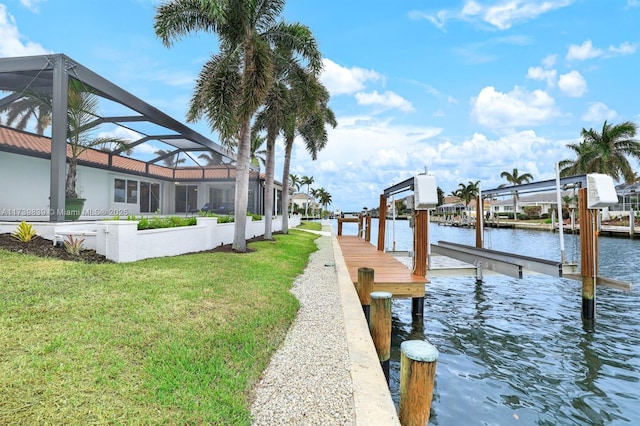 view of dock with glass enclosure, a water view, boat lift, and a lawn