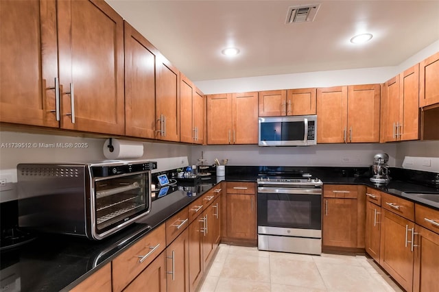 kitchen featuring light tile patterned floors, stainless steel appliances, and sink