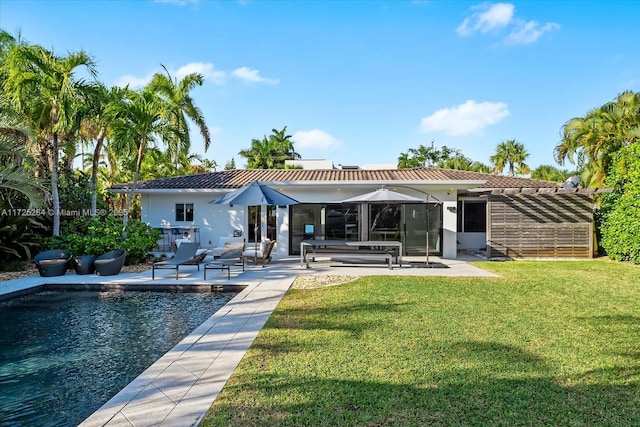 back of property with a yard and a patio