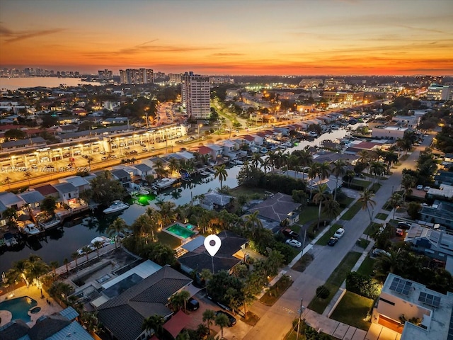 aerial view at dusk featuring a water view