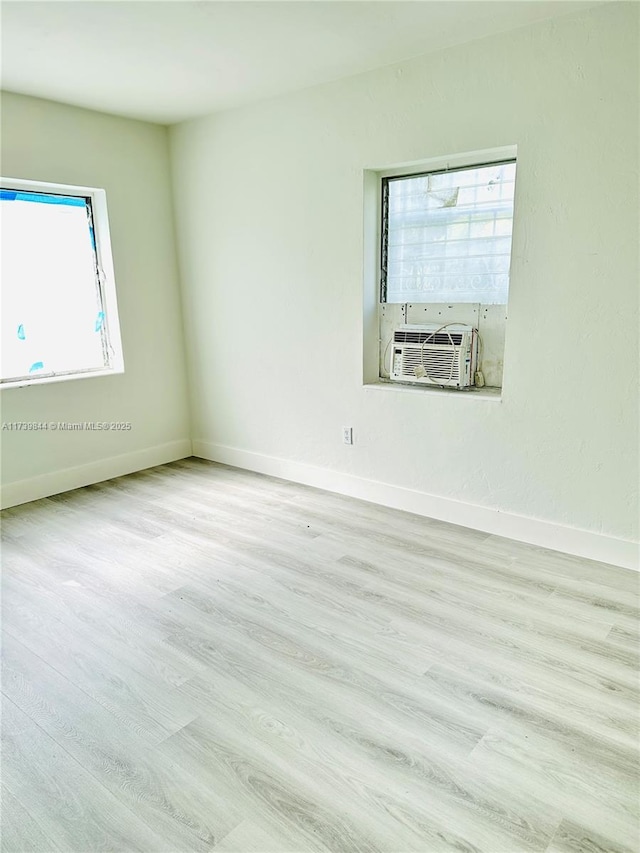 spare room with cooling unit and light hardwood / wood-style flooring